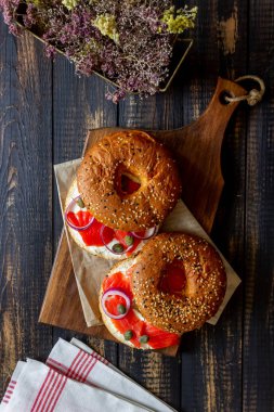 Somonlu simit, beyaz krem peynir ve ahşap arka planda kapari. Yemek tarifleri. Sağlıklı beslenme. Kahvaltı..