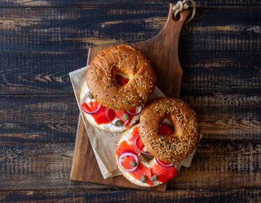 Somonlu simit, beyaz krem peynir ve ahşap arka planda kapari. Yemek tarifleri. Sağlıklı beslenme. Kahvaltı..