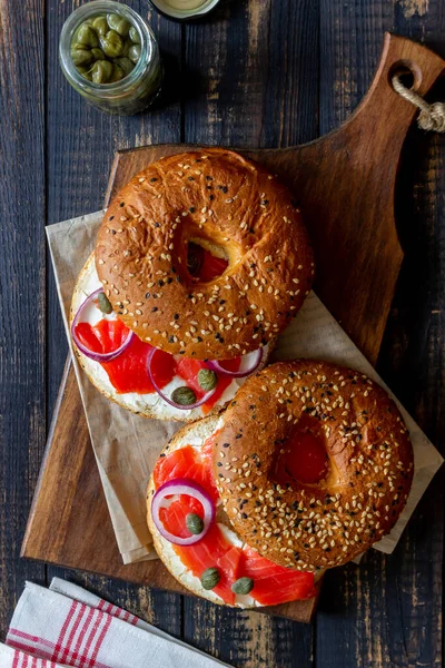 Somonlu simit, beyaz krem peynir ve ahşap arka planda kapari. Yemek tarifleri. Sağlıklı beslenme. Kahvaltı..