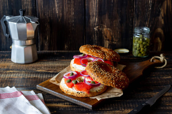 Bagels with salmon, white cream cheese and capers on a wooden background. Recipes. Healthy eating. Breakfast.