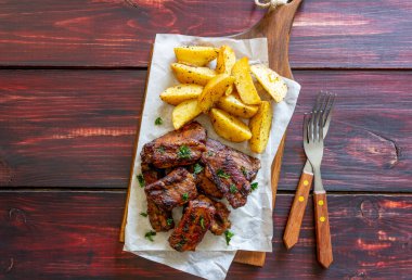 Ahşap arka planda patatesli domuz pirzolası. Barbekü. Izgara yap. Amerikan mutfağı. Tarif