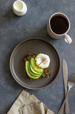 Avokado ve haşlanmış yumurtalı sandviç. Sağlıklı vejetaryen yemekleri yemek. Kahvaltı.