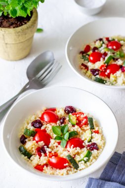 Domatesli kuskus salatası, biber, kabak ve kızılcık. Vejetaryen yemeği. Diyet olsun. Sağlıklı beslenme