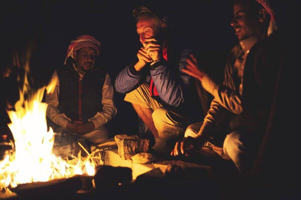 Wadi Rum Desert, Jordan. Circa November, 2019. A group of people keeping themselves warm on a very cold night in the desert.