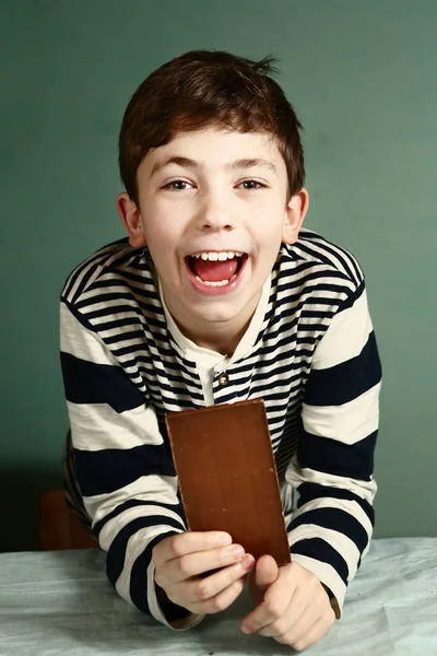 Menino pré-adolescente feliz com barra de chocolate — Fotografia de Stock