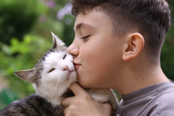 Gelukkige jongen houdt kat glimlachend close-up foto — Stockfoto