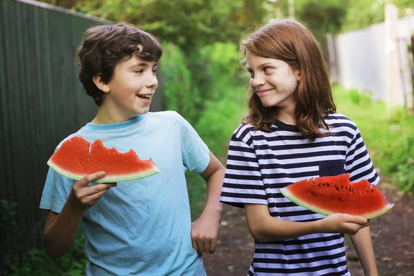 Adolescent souriant garçon amis tenir melon d'eau tranche manger — Photo