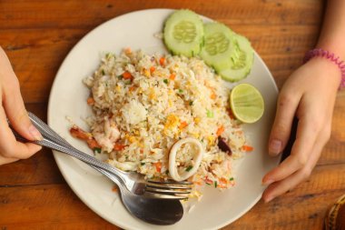 karides kaşık salatalık ve eller ile deniz ürünleri ile kavrulmuş Asya Tayland pirinç