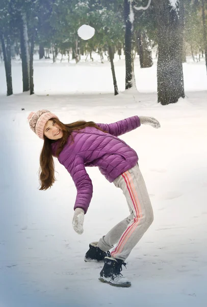 Tonåring vacker flicka spela snö bollar i vinter park leende på — Stockfoto