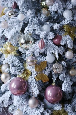 Kar ve oyuncaklarla süslenmiş Noel ağacının fotoğrafı.