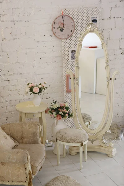 Chambre à coucher intérieur avec miroir fauteuil table horloge pivoine fleurs Photo De Stock