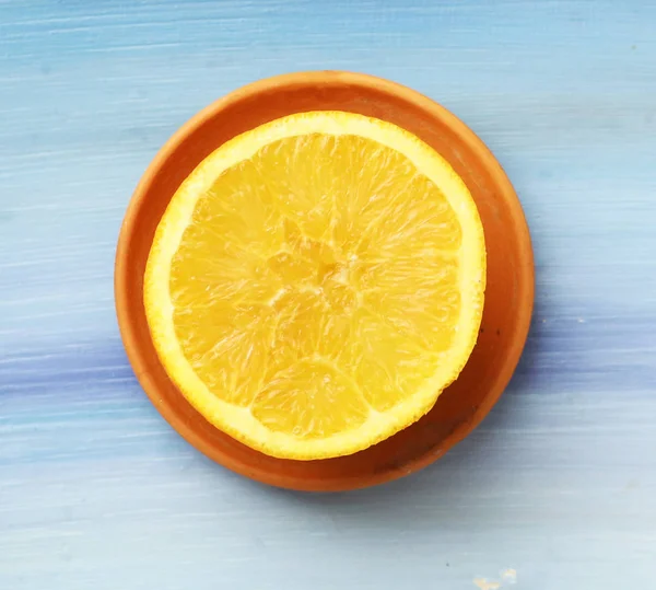 Cut orange half on blue wooden board background close up top vie — 图库照片