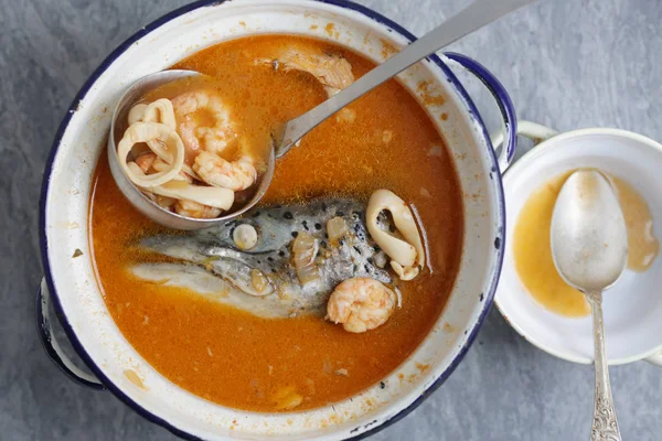 Soupe de poisson avec tête de saumon et Tom Igname pâte dans une grande casserole dessus Images De Stock Libres De Droits