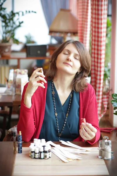 有茶具的咖啡店里的年轻女子用吸墨机近照闻香水 — 图库照片