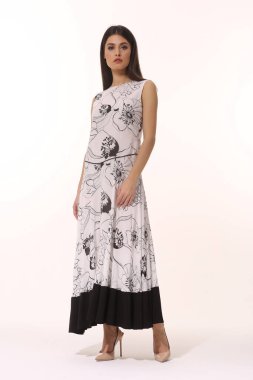 Genç esmer iş kadını yönetici uzun kahverengi kısa kollu elbiseyle poz veriyor tüm vücut uzunluğu beyaza izole edilmiş.