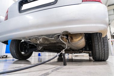 Emisyon kontrolü. Araç kontrol istasyonundaki eski bir arabanın egzozunda gaz sensörü var.