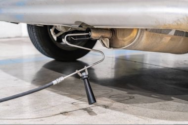 Emisyon kontrolü. Araç kontrol istasyonundaki eski bir arabanın egzozunda gaz sensörü var.