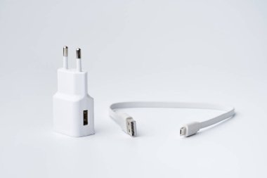 Beyaz USB güç adaptörü ve divice için kablo kopyalama alanı olan beyaz bir arkaplanda izole edildi.