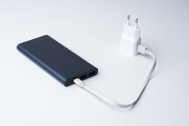 Bağlı beyaz USB güç adaptörü, kablo ve mavi güç bankası beyaz arka planda izole edilmiş divice için. 