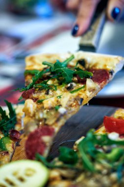 Bir spatula üzerinde bir dilim pizzanın yakın çekimi..