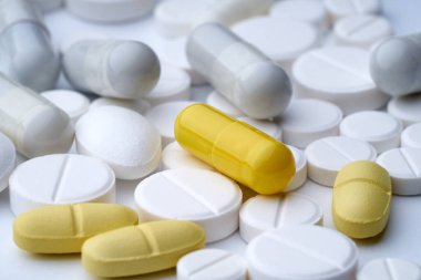 Beyaz arka planda, dokusu farklı olan çok renkli hapların yakınlaştırılması.