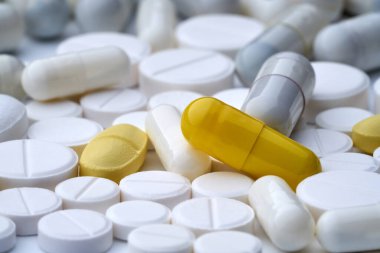 Beyaz arka planda, dokusu farklı olan çok renkli hapların yakınlaştırılması.