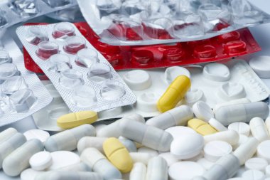 Çok renkli hapların ve uyuşturucunun boş ambalajlarının beyaz arkaplandaki dokusu ile kapatılması.