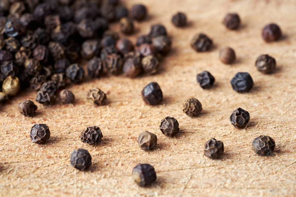 Closeup Heap Whole Black Pepper Seeds Wooden Background — Stock Photo, Image