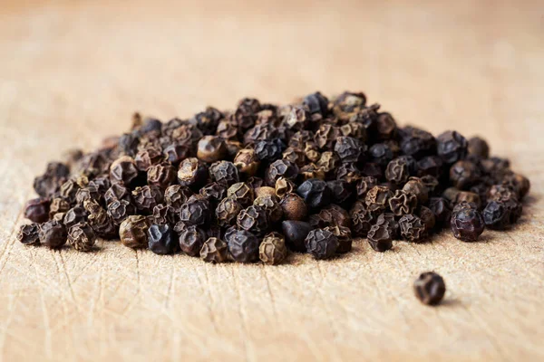 Closeup Heap Whole Black Pepper Seeds Wooden Background Royalty Free Stock Photos