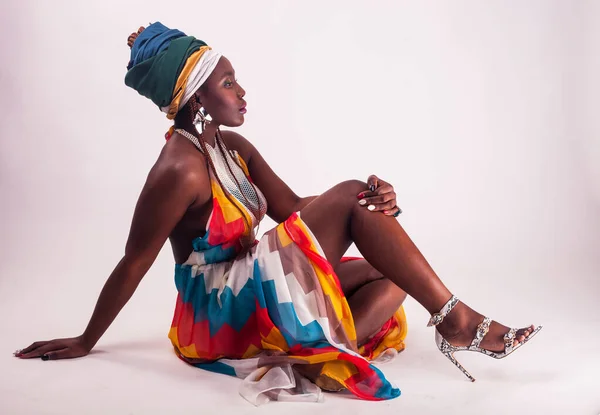 Студийный модный портрет молодой африканской женщины в летнем платье и этнической головной убор, белый фон . — стоковое фото