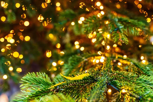 Outdoor decorated Christmas tree with light garland, selective focus