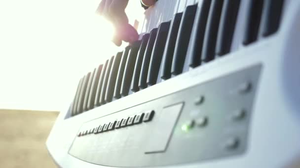Bir Adam Plajda Elektronik Piyano Çalar Güneş Işınları Doğrudan Kameraya — Stok video