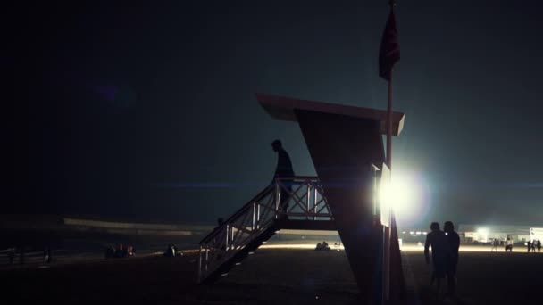 Спасательная вышка ночью с прожектором на заднем плане. Дубай. ОАЭ . — стоковое видео