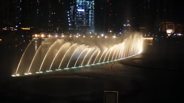 Dubai, Verenigde Arabische Emiraten - januari 2018: Fontein in de buurt van Burj Khalifa verlicht door de stad. — Stockvideo