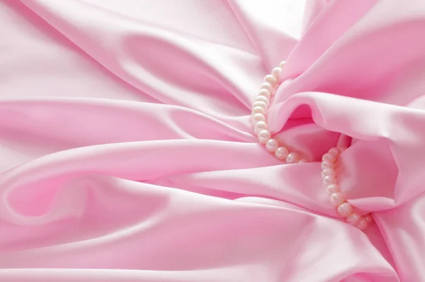 Liso elegante fondo de seda rosa con perlas, hermosas cortinas de seda. Espacio para texto — Foto de Stock