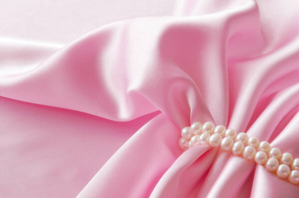 Smooth elegant rose silk background with pearl, Beautiful silk drapes. Space for text