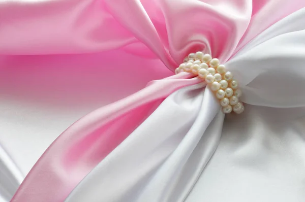 Détail de tissu de soie drapé blanc et rose avec bijoux en perles — Photo