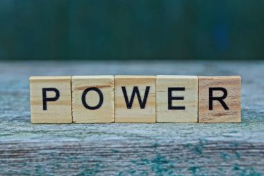 Kelime gücü gri bir masada kahverengi ahşap harflerden yapılır.