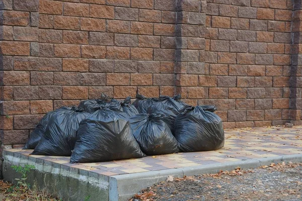 Lot Black Plastic Bags Garbage Sidewalk Brown Brick Fence — Stock Photo, Image