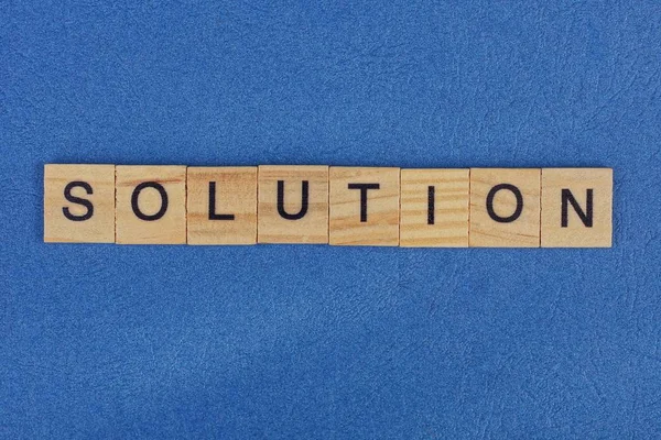 Woord Oplossing Van Bruine Houten Letters Ligt Een Blauwe Tafel — Stockfoto