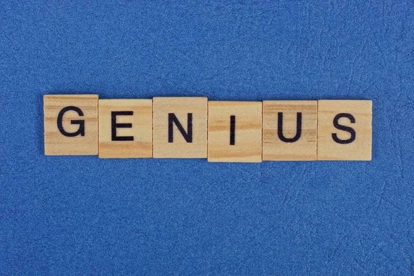 茶色の木製の文字からの単語の天才は青いテーブルの上にあり — ストック写真