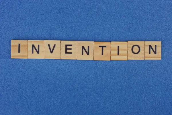 Parola Invenzione Fatta Lettere Legno Marrone Trova Tavolo Blu — Foto Stock