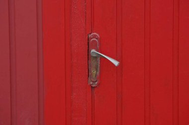 Kırmızı metal duvardaki gri kapı tokmağı