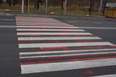 Beyaz ve kırmızı işaretli gri asfalt yol