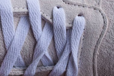 Gri süet spor ayakkabısında beyaz dantel.