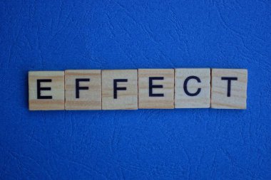 Kahverengi ahşap harflerden oluşan kelime efekti mavi bir masada yatıyor.