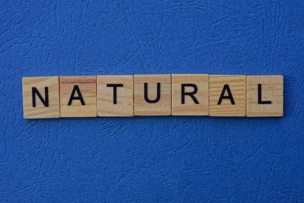 Słowo Naturalne Wykonane Brązowych Liter Drewnianych Leży Niebieskim Stole — Zdjęcie stockowe