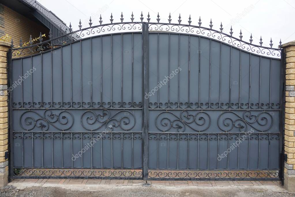 one gray metal gates and doors with a black  forged pattern