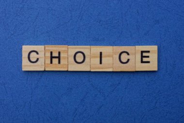 Kahverengi ahşap harflerden yapılmış kelime seçimi mavi bir masada yatıyor.