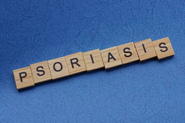 Kahverengi ahşap harflerden yapılmış sedef mavi bir masada yatıyor.